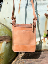 Image of back side of Yipee Kiyay crossbody purse. Solid veggie tan leather with back pocket with magnetic closure and tooled leather detail on the top. Zipper closure.