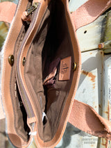 Image of one interior pocket of the yipee kiyay tote purse with brown cloth interior liner and conceal carry holster, STS Ranchwear leather patch, and magnetic snap closure.